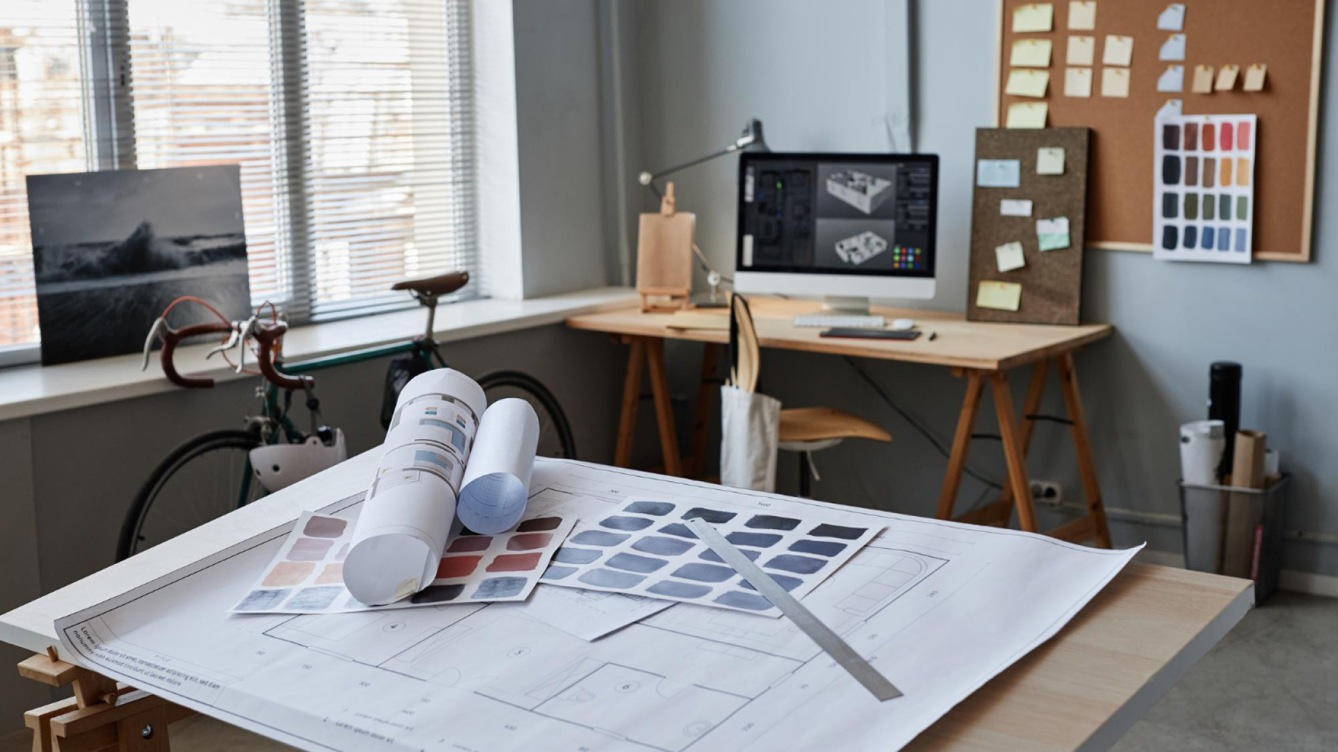 Çayyolu’nda hizmet veren bir mimarlık ofisinde proje değerlendirmesi yapan ekip; masa üzerinde plan çizimleri, malzeme örnekleri ve bilgisayar bulunuyor.